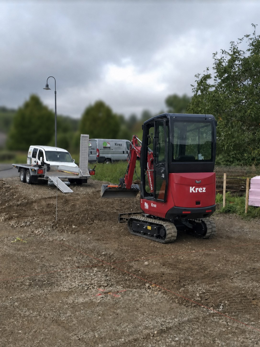 Minibagger und Firmenfahrzeug von Krez Gartenbau bei Erdarbeiten