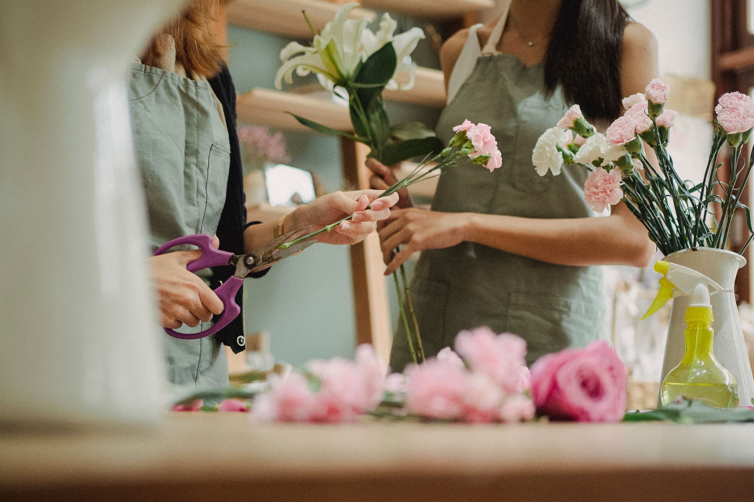 Mitarbeiterinnen arrangieren Blumen in einem lokalen Einzelhandelsgeschäft